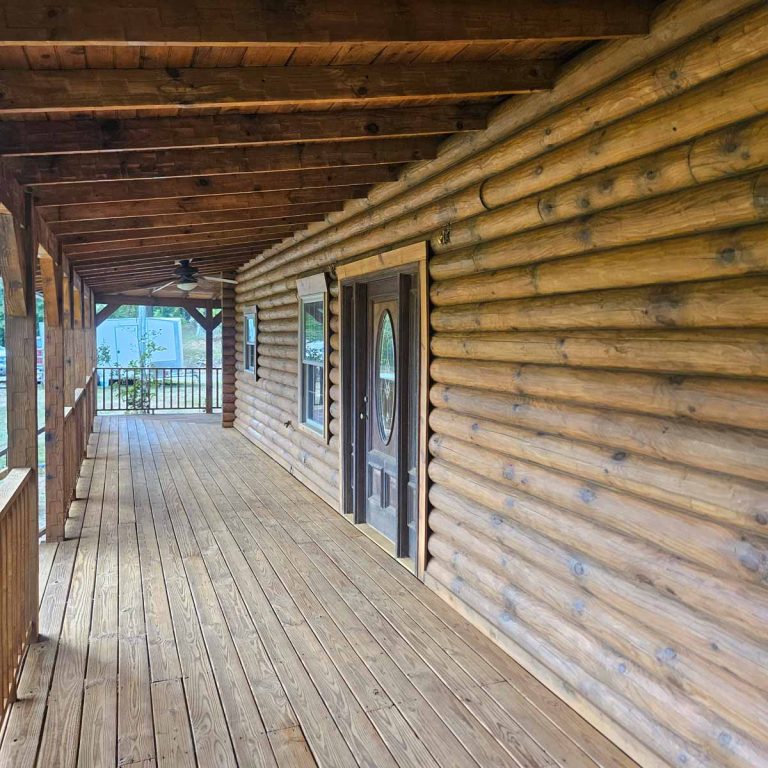 front porch of a log cabin with dark honey stain