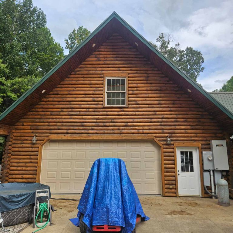 garage view of a log cabin with dark honey stain